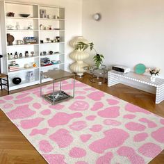 a living room filled with furniture and a pink rug