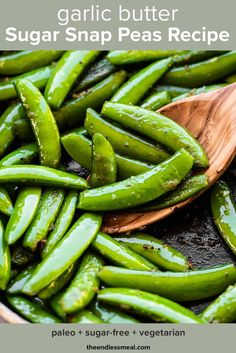 green beans are being cooked in a skillet with a wooden spoon on the side