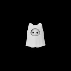 a white cat figurine with eyes and a cape on it's head