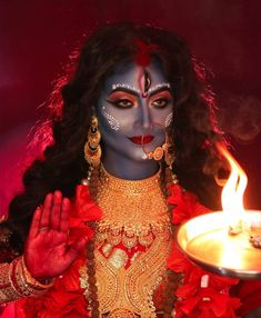 a woman dressed in costume holding a candle