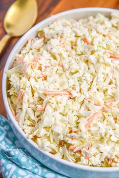 a white bowl filled with coleslaw on top of a blue and white napkin