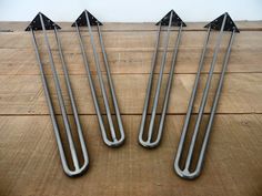 four metal arrows sitting on top of a wooden floor