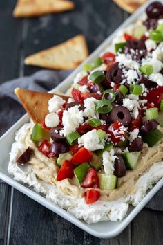 an appetizer with olives, tomatoes, cucumbers and feta cheese