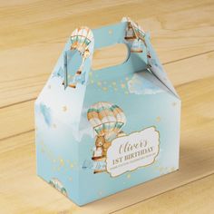 a baby shower box with hot air balloons on the front and sides, sitting on a wooden surface