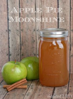 an apple and cinnamon sitting next to each other on a wooden table with the words apple pie moon shine above it