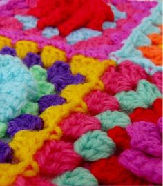 a crocheted blanket with multicolored flowers on it