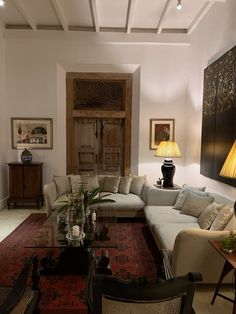 a living room filled with lots of furniture next to a wall mounted painting on the wall