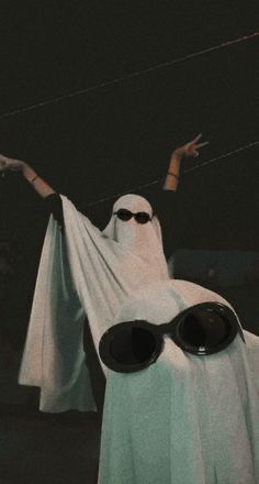 a person wearing sunglasses and a ghost costume