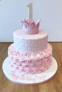 a pink and white birthday cake with a crown on top