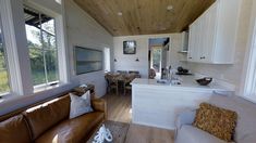 a living room filled with furniture next to a kitchen and dining area in a home