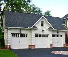 a white house with two garages and three windows