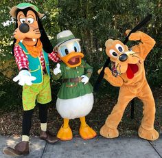 goofy, pluto and scooby pose for a photo