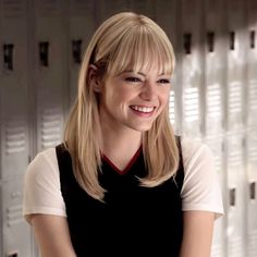 a woman standing in front of lockers smiling