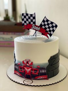 a birthday cake decorated with race cars and flags