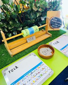 a table topped with lots of books and writing paper on top of green grass covered ground