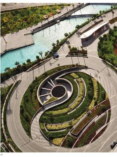 an aerial view of a circular garden with trees and plants in the center, surrounded by water