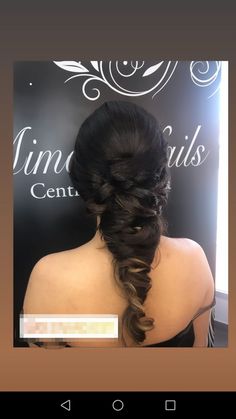 the back of a woman's head with long hair and braids in it