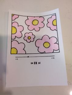 a piece of paper with pink and yellow flowers on it, sitting on top of a table