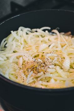 onions are being cooked in a skillet on top of the stove with seasoning