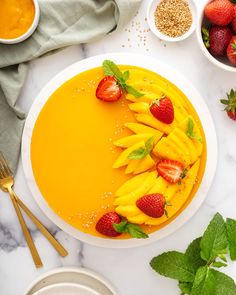 a plate with fruit on top of it next to bowls of strawberries and oranges