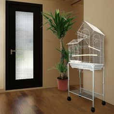 a bird cage sitting on top of a table next to a door