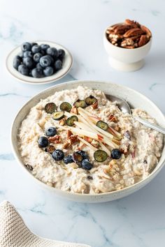 a bowl of oatmeal with blueberries and pecans on the side