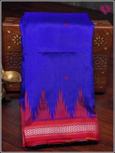 Luxurious Berhampuri pure silk saree in a blue with double pallu in red color. The body features small buttas with red phoda kumba border. Grand red double pallu has Ikkat woven patterns. Steal any special occasion with most vibrant Berhampuri pure silk. Colroful double pallu with Ikkat patterns, stunning color combo on body is just enough to make a statement. Part of the package is an unstitched blouse piece. Blouse - Unstitched. Fall and Pico - Done. Please note: Color may vary slightly from t Traditional Blue Raw Silk Saree, Blue Silk Traditional Wear With Handloom, Blue Handloom Katan Silk Saree, Blue Raw Silk Saree For Puja, Blue Raw Silk Dupatta For Puja, Blue Silk Saree For Puja, Blue Handloom Dupatta For Traditional Ceremonies, Blue Tussar Silk Traditional Wear For Puja, Handloom Blue Dupatta For Traditional Ceremonies