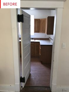 an open door leading to a kitchen with wooden cabinets and white walls in the background