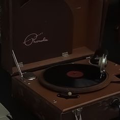 an old record player sitting on top of a suitcase