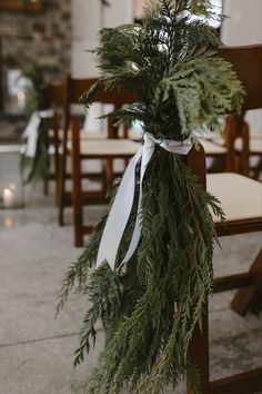 Evergreen hanging off chair in aisle for winter wedding, tied with a simple white ribbon Winter Wedding Simple, Winter Wedding Aisle, Classic Winter Wedding, Winter Ceremony, Christmas Wedding Themes, Evergreen Wedding, Christmas Wedding Inspiration, Winter Wedding Table, Winter Wedding Centerpieces