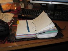 an open notebook sitting on top of a desk next to a keyboard