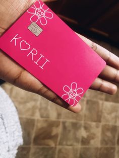 a person holding a pink card with the word koril on it in their hand