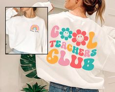 a woman wearing a white sweatshirt with the words teachers club on it and a rainbow flower