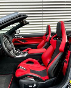 the interior of a sports car with red and black seats