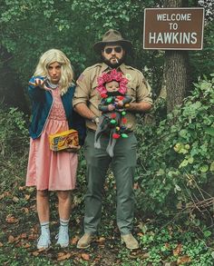 a man and woman standing next to each other in front of a sign that says welcome to hawks