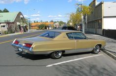 an old car is parked on the side of the road