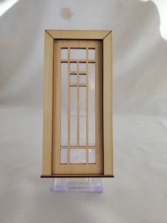 a small wooden frame sitting on top of a white table next to a glass window