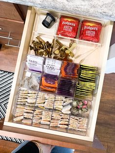 a drawer filled with lots of food and some gold scissors on top of the drawers