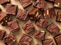 pieces of chocolate fudge cake sitting on top of a piece of parchment paper