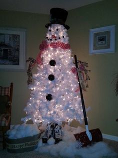 a white christmas tree decorated with lights and a snowman