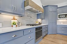 a kitchen with blue cabinets and white counter tops