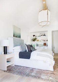 a bedroom with a large bed and white walls