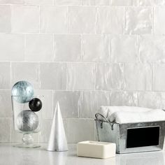 some silver and black objects are sitting on a counter top in front of a white brick wall