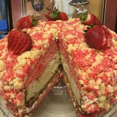 a cake with strawberries on top is cut in half and ready to be eaten