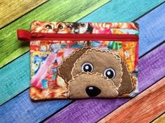 a small purse with a dog on it's face and colorful stripes in the background