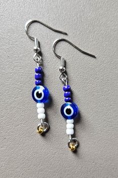 Evil eye earrings Sterling Silver Evil Eye Dangle Earrings, Elegant Dangle Earrings With Evil Eye, Blue Sterling Silver Evil Eye Earrings, Blue Evil Eye Dangle Earrings, White Evil Eye Dangle Jewelry, Evil Eye Round Earrings For Gift, Blue Round Evil Eye Earrings, Silver Round Evil Eye Earrings, Gift White Earrings With Diamond Eyes