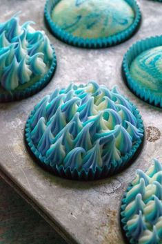 blue and green decorated cookies sitting on top of a cookie sheet