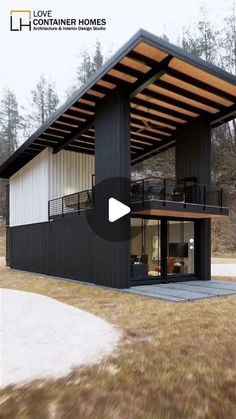 a black and white house sitting on top of a grass covered field