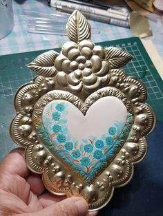 a heart shaped brooch sitting on top of a table