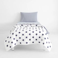 a bed with blue and white stars on the comforter is shown in this image